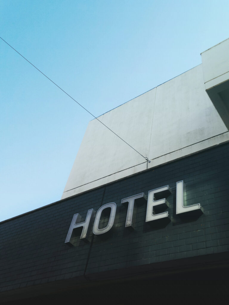 View from the street of a hotel sign against a blue sky