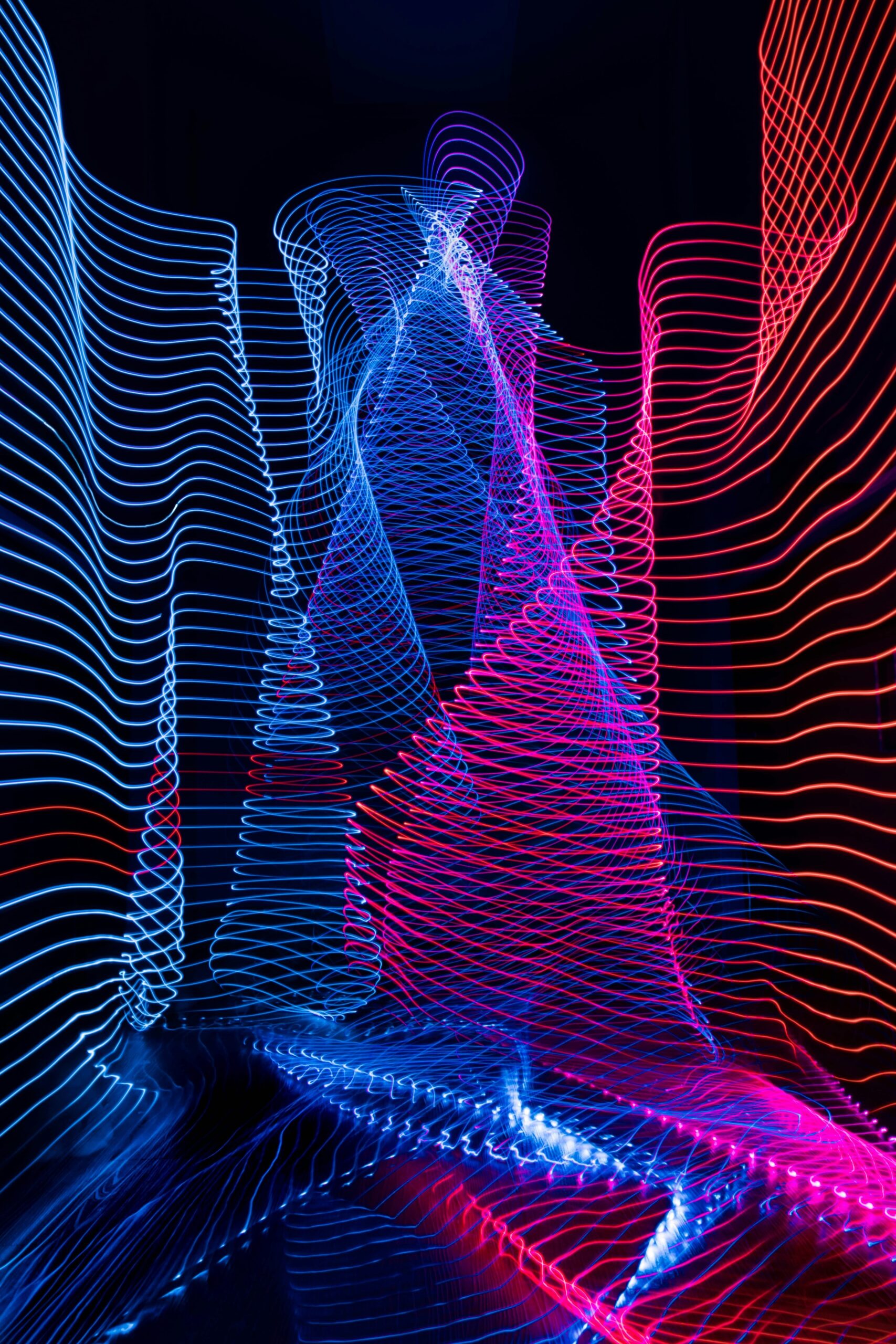 Bright squiggly lights in blue and fuchsia on dark background